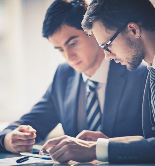 Image,Of,Two,Young,Businessmen,Using,Touchpad,At,Meeting